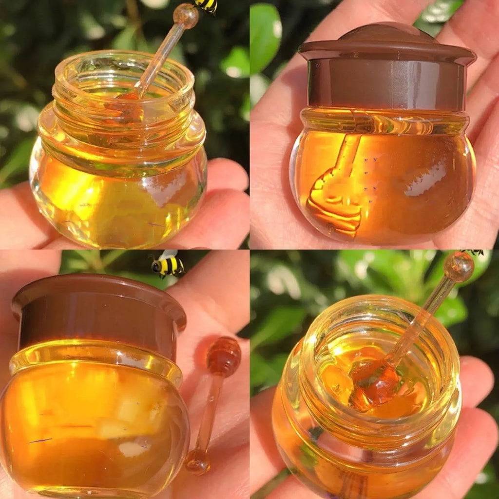 Glass jar of honey lip mask with a honey dipper, showcasing its moisturizing texture and rich color.